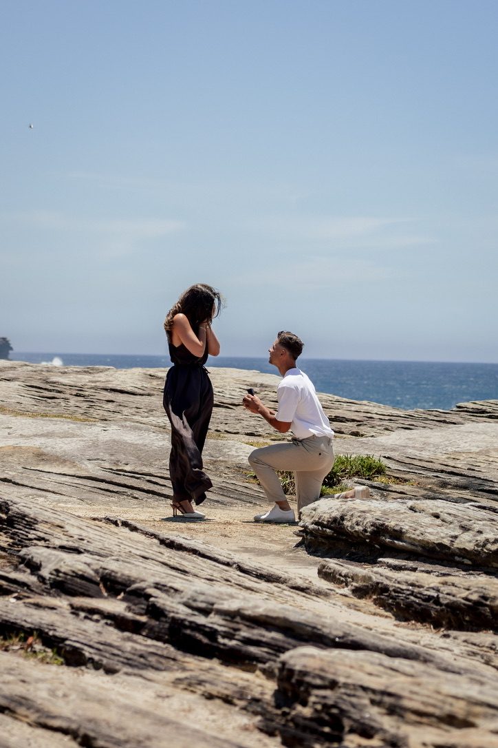 David proposing to Isabella on a coastal cliff